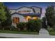 Charming two-story home with manicured landscaping, sidewalk, and inviting entrance with illuminated bushes at 1882 W 67Th Ave, Denver, CO 80221