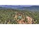 Aerial view of a house nestled in the woods with a barn, marked by an arrow at 26526 Gray Buck Trl, Conifer, CO 80433