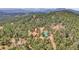Aerial view of the house and barns hidden within a forest landscape at 26526 Gray Buck Trl, Conifer, CO 80433