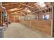 Spacious horse barn interior featuring horse stalls with metal gates and wood walls at 26526 Gray Buck Trl, Conifer, CO 80433