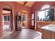 Bathroom features a arched window with natural light, wood-paneled cabinets, and warm terra-cotta paint at 26526 Gray Buck Trl, Conifer, CO 80433