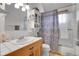 This bathroom features a glass-doored shower with a bathtub and natural wood cabinets at 26526 Gray Buck Trl, Conifer, CO 80433