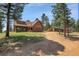 This exterior showcases a home with earthy tones, with an outbuilding to the side at 26526 Gray Buck Trl, Conifer, CO 80433