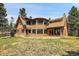 Charming home exterior featuring a unique architectural design, spacious yard and lush surroundings at 26526 Gray Buck Trl, Conifer, CO 80433