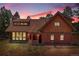 Charming home with unique architecture and a beautiful sunset backdrop, surrounded by mature trees at 26526 Gray Buck Trl, Conifer, CO 80433