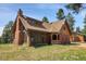 Rustic exterior showcases unique architecture with stone accents and a well-maintained lawn at 26526 Gray Buck Trl, Conifer, CO 80433