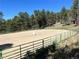 Equestrian sand arena with green perimeter fencing creating a safe and controlled riding environment for horses at 26526 Gray Buck Trl, Conifer, CO 80433