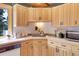 Well-lit kitchen featuring light wood cabinetry, tile countertops, and ample storage at 26526 Gray Buck Trl, Conifer, CO 80433