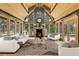 Bright living room features a cozy fireplace, vaulted ceilings, and expansive windows with scenic views at 26526 Gray Buck Trl, Conifer, CO 80433