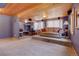 Cozy living room with raised platform, wood-paneled ceiling, and natural light at 26526 Gray Buck Trl, Conifer, CO 80433