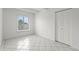 Unfurnished bedroom featuring a large window and white tile flooring at 9725 E Harvard Ave # 323, Denver, CO 80231