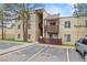Multi-story condo building with private balconies, complemented by parking areas and mature trees, creating a comfortable living environment at 9725 E Harvard Ave # 323, Denver, CO 80231