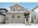 Charming two-story home with gray siding, white trim, and inviting front porch at 7376 Watercress Dr, Littleton, CO 80125