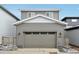 Attached two-car garage with a gray carriage door complementing the siding at 7376 Watercress Dr, Littleton, CO 80125