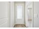 Hallway with wood-look floors and glass door that allows for natural light to enter the home at 7376 Watercress Dr, Littleton, CO 80125
