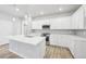Modern kitchen boasts white cabinets, stainless steel appliances, and a large island at 7376 Watercress Dr, Littleton, CO 80125