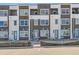 Modern townhome exterior with brick facade, private balconies, and vibrant blue entry doors at 374 N Geneva St, Aurora, CO 80010
