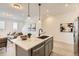 Modern kitchen with a center island with bar seating and pendant lighting, an open-concept living space at 374 N Geneva St, Aurora, CO 80010