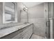 Elegant bathroom showcasing a granite countertop, ample lighting, and marble-tiled walls at 703 S Oneida Way, Denver, CO 80224