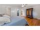 Bedroom featuring hardwood floors and convenient sliding door access to a bathroom at 703 S Oneida Way, Denver, CO 80224