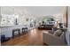 Spacious living room featuring hardwood floors, comfortable seating, and a seamless flow to the kitchen at 703 S Oneida Way, Denver, CO 80224