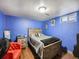 Bedroom with blue walls, hardwood floors, complemented by natural light from the window at 7870 Kimberly St, Commerce City, CO 80022