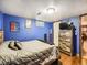 Bright blue bedroom with hardwood floors and warm lighting, a very cozy space at 7870 Kimberly St, Commerce City, CO 80022