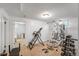 Home gym featuring various exercise machines and weights and an open doorway to a connecting bedroom with desk at 6023 E 6Th Avenue Pkwy, Denver, CO 80220