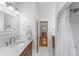 Bright bathroom featuring a marble countertop vanity and a shower with white subway tile at 6023 E 6Th Avenue Pkwy, Denver, CO 80220