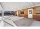 Covered patio, brick walls, concrete floor, snowy yard at 914 Quari Ct, Aurora, CO 80011