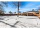 Spacious backyard with covered patio and snow on the ground at 914 Quari Ct, Aurora, CO 80011