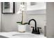 Close-up of a bathroom vanity featuring a sleek faucet, a decorative plant, and modern design at 914 Quari Ct, Aurora, CO 80011