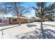 Brick ranch home with a snow covered front yard and landscaping at 914 Quari Ct, Aurora, CO 80011