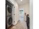 Upstairs hallway with laundry closet featuring a modern stacked washer and dryer at 12336 W 52Nd Ave, Wheat Ridge, CO 80033
