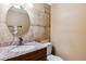 Neutral half-bath featuring tile backsplash, marble countertop, and wood vanity at 3616 W Radcliff Ave, Denver, CO 80236