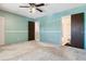 Bedroom with teal walls, ceiling fan, and ensuite bath at 3616 W Radcliff Ave, Denver, CO 80236