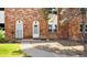 Brick townhouse exterior showcasing a walkway leading to two front doors with arched doorways at 3616 W Radcliff Ave, Denver, CO 80236