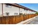 Exterior view of townhome with fenced patio and well-maintained landscaping and neutral-toned exterior at 3616 W Radcliff Ave, Denver, CO 80236