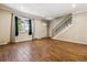 Inviting living room with hardwood floors, staircase, and large window for natural light at 3616 W Radcliff Ave, Denver, CO 80236
