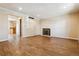 Spacious living room with fireplace and open doorway, featuring wood-look flooring at 3616 W Radcliff Ave, Denver, CO 80236
