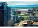 City skyline view featuring modern buildings, sports arena, mountains, and train tracks winding through landscape at 1700 Bassett St # 1808, Denver, CO 80202