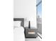 Bedroom with modern nightstand, lamp, and expansive city views through a large window at 1700 Bassett St # 1808, Denver, CO 80202