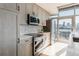 Modern kitchen with stainless steel appliances, light wood cabinets, and access to a balcony with city views at 1700 Bassett St # 1808, Denver, CO 80202