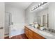 Bathroom featuring double vanity, large mirror with vanity lights, and separate shower and tub at 3205 E 102Nd Pl, Thornton, CO 80229
