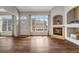 Cozy living room featuring hardwood floors, fireplace, archways and ample natural light at 3205 E 102Nd Pl, Thornton, CO 80229