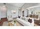 Bright living room featuring a white sofa, patterned pillows, and hardwood floors at 3205 E 102Nd Pl, Thornton, CO 80229