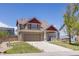 Attractive two-story home with a brick facade, manicured lawn, concrete driveway, and a welcoming front porch at 217 Peabody St, Castle Rock, CO 80104