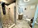 Modern bathroom with walk-in shower, patterned tile flooring, and sleek vanity at 3818 S Dallas St, Aurora, CO 80014