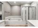 Cozy bathroom featuring a soaking tub and a glass-enclosed shower at 3818 S Dallas St, Aurora, CO 80014