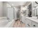 Bright bathroom featuring a soaking tub, glass shower, and double vanity at 3818 S Dallas St, Aurora, CO 80014